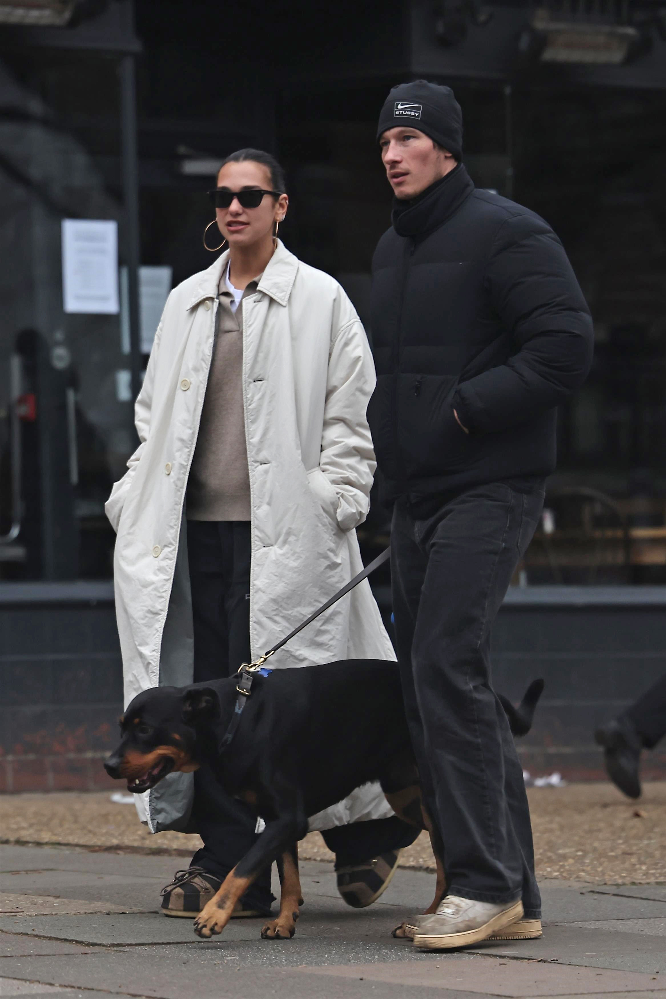 Dua Lipa was spotted in London wearing a khaki trench coat, a polo sweater, and statement Moon Boots