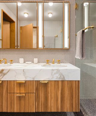 slatted wood bathroom vanity with a thick marble countertop