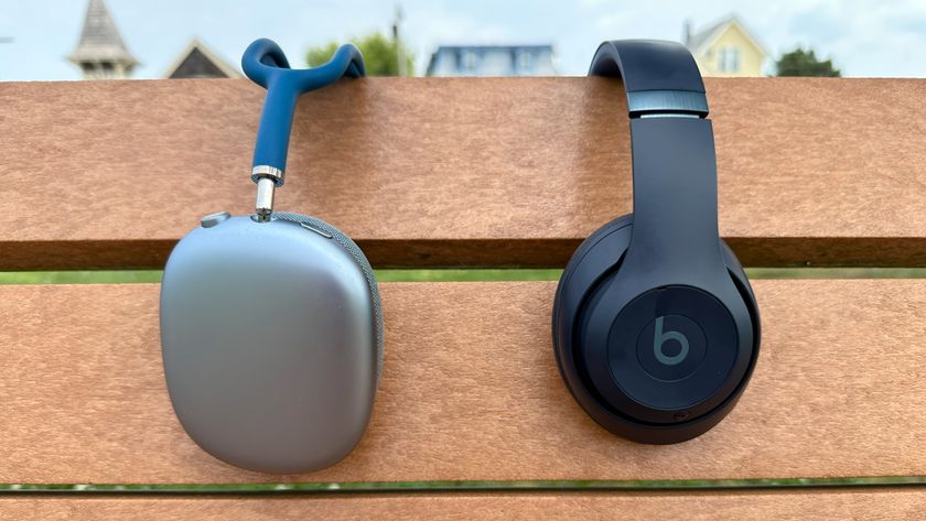 AirPods Max (left) hanging from a park bench beside Beats Studio Pro (right).