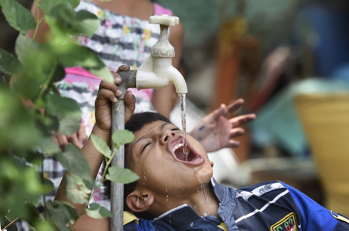 A boy quenches his thirst at a water tap during a scorching heat wave, on May 15, 2017, in New Delhi, India.