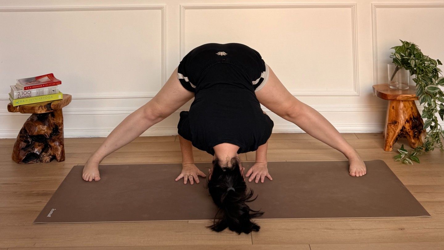 Purdon showing wide legged forward fold on yoga mat
