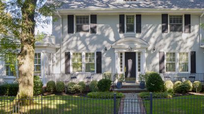 a front yard with shrubs in front 