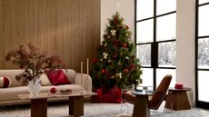 Living room with crittal doors, wooden wall, beige sofa, modern armchair, marble coffee table, and christmas tree