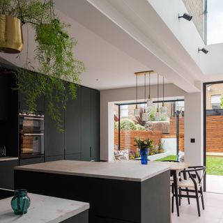 dark green kitchen with kitchen island and dining table