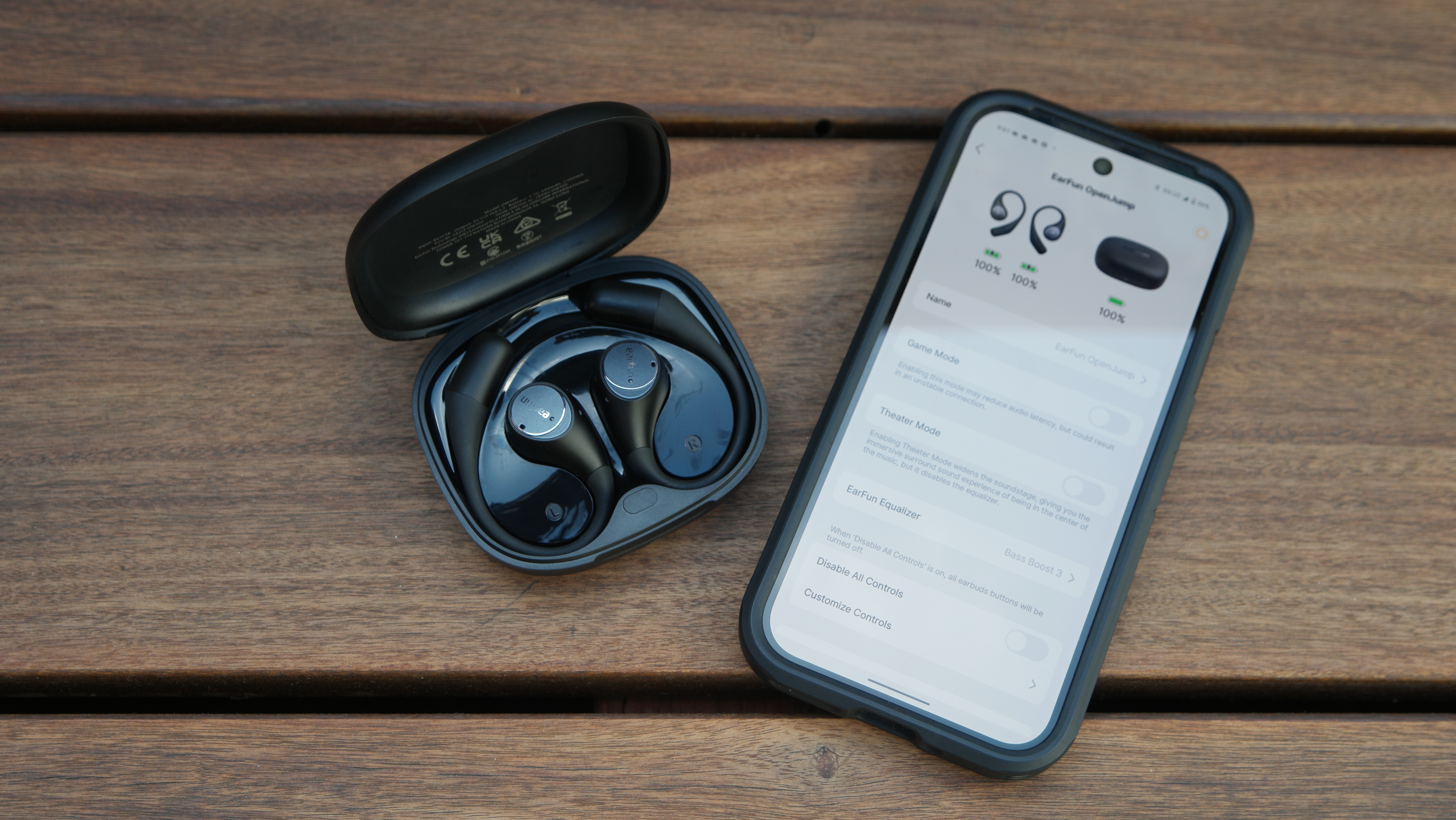 EarFun OpenJump in their case, next to a Google Pixel 9