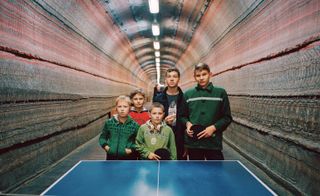 family standing in a front of a table tennis table in a tunnel