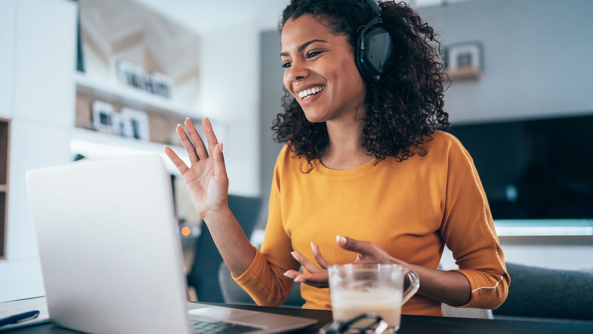 Woman wearing headphones speaking at home on a videoconference