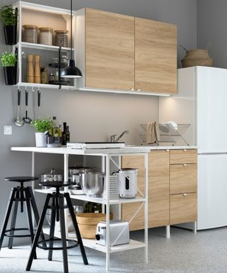 Scandinavian style IKEA kitchen with light wood cabinets and white countertops and hardware