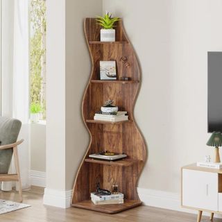 A wooden wavy bookcase in the corner of a room