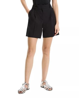 Model wearing black pleated shorts