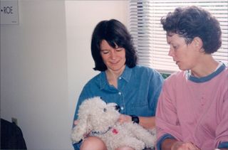 Tam O’Shaughnessy and Sally Ride sharing a tender moment with their bichon pup named Gypsy.