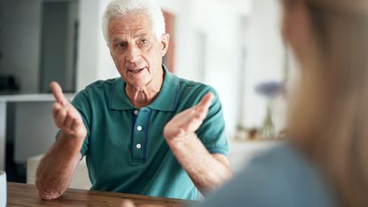 Senior man gestures while talking