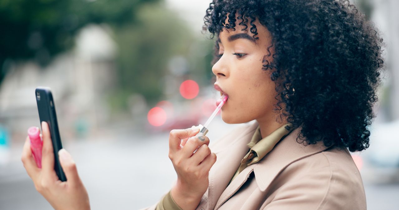 Outdoor, lipstick and woman with a smartphone