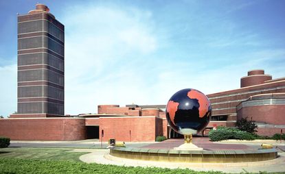 Brick building with black and red globe sculpture outside