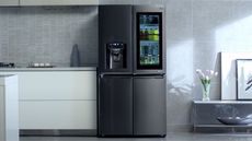 LG vs Samsung: the LG InstaView Refrigerator in a kitchen, stood beside white floating countertops