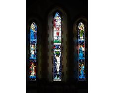 The three stained glass windows together that make up the East window, designed by the Pre-Raphaelite artist Edward Burne-Jones, at St James Church, Staveley, Cumbria.