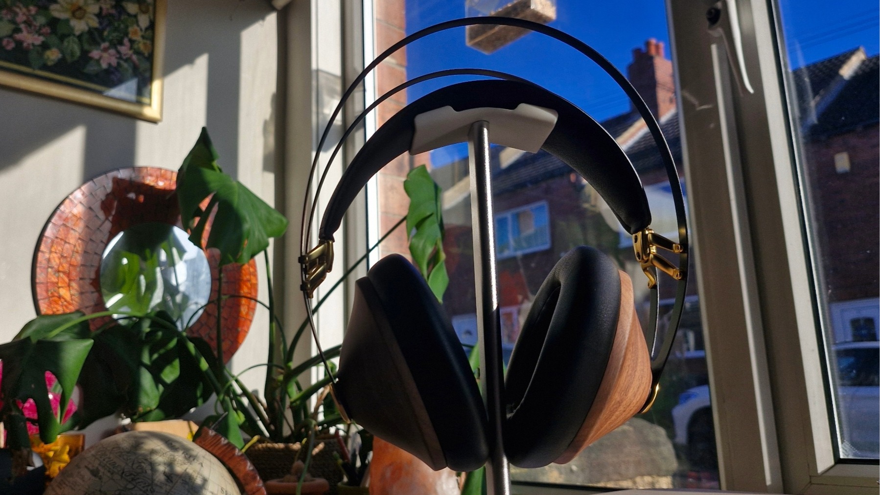 Meze Audio 99 Classics 2nd Gen over-ear headphones on a headphone stand in front of a window