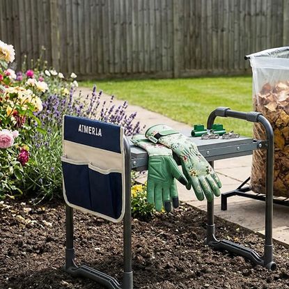 Ergonomic kneeler, gloves and rolling yard cart in garden.