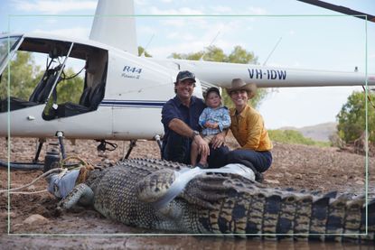 Matt Wright and his wife Kaia and their son Banjo on Wild Croc Territory with crocodile in front