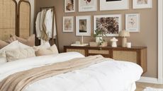 A cozy bedroom with wood-framed rattan room divider, clothes rail, framed wall art and bed