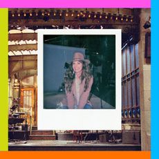 a polaroid of photographer mary ellen matthews smiling and wearing a jacket and hat in front of the snl stage