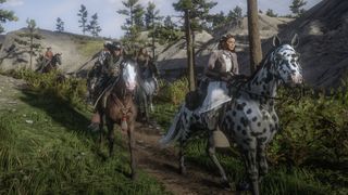Red Dead Online - Several players on horses ride down a dirt path together facing the camera