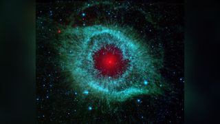 This infrared image from NASA's Spitzer Space Telescope shows the Helix nebula, a cosmic starlet often photographed by amateur astronomers for its vivid colours and resemblance to a giant eye. An optimised and digitally enhanced version of a NASA/ ESA image.