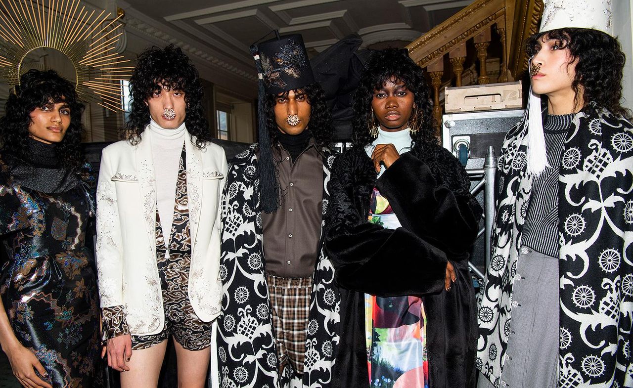 Group of models stood together wearing dark clothing &amp; large septum piercings