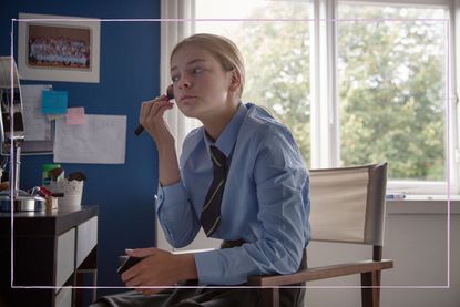 Teenager doing her makeup in school uniform 