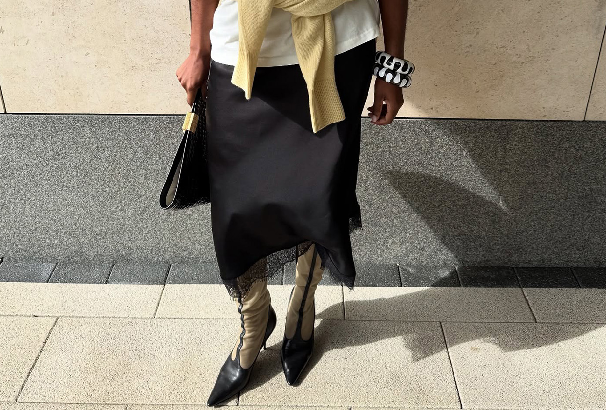 Marilyn Nwawulor-Kazemaks wearing a white tee, black lace-trim skirt, and yellow sweater.