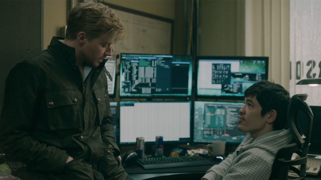 Jack Lowden on the left, talking to Christopher Chung in Slow Horses.