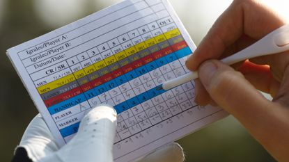 Close-up of a player marking a scorecard
