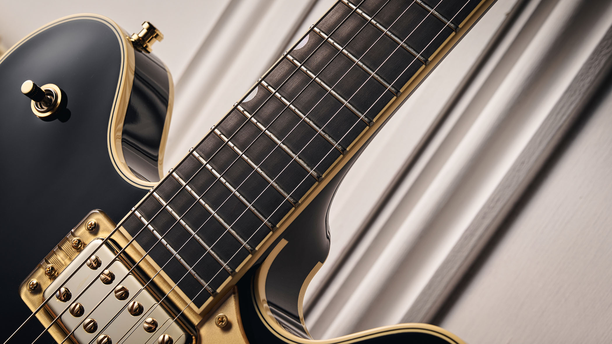 Gretsch Professional Collection Broadkaster LX Center Block: the handsome semi-hollow is finished in black with gold hardware and here is photographed in close-up.