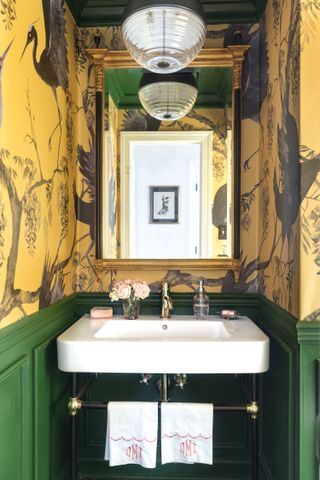 A bathroom with yellow wallpaper and green paint