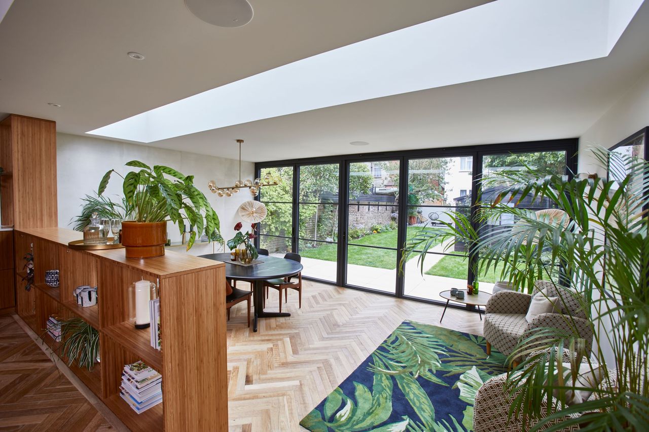 The kitchen-diner extends into the new conservatory, which has bifold doors looking out onto the garden as well as a bookcase, which divides the seating area from the kitchen