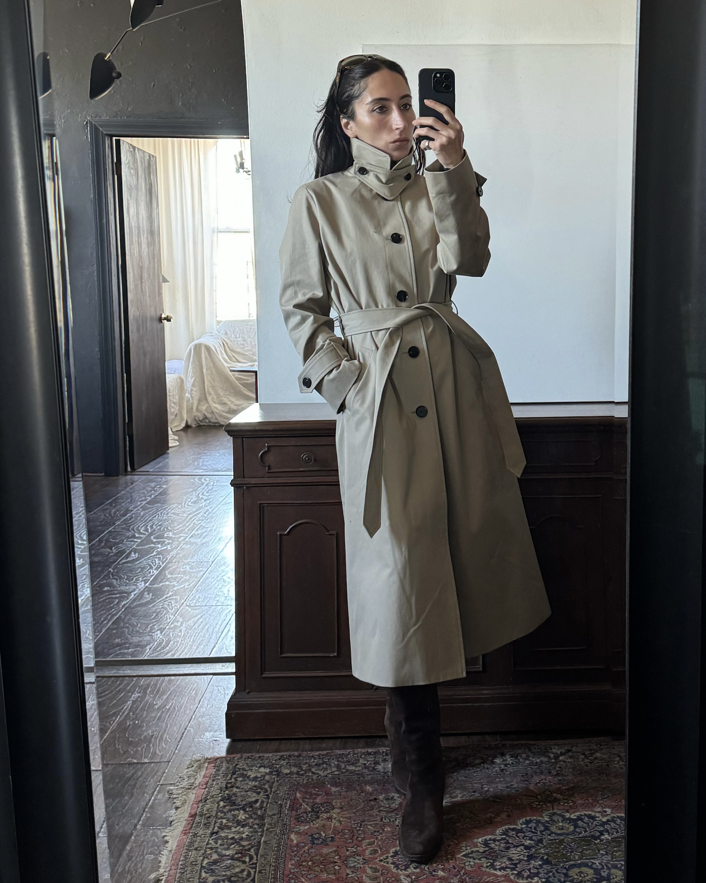 Alexis Badiyi wearing a trench coat and pants