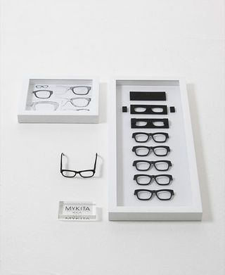 Black framed glasses in white box and on white table