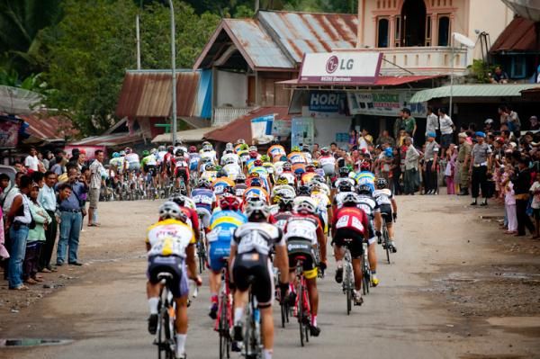 Riders pass an old village