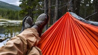 Person relaxing on hammock wearing socks and sandals