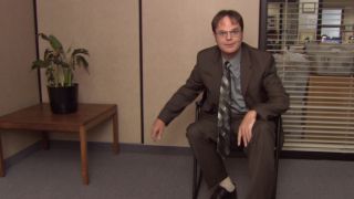 Dwight in a chair in The Office