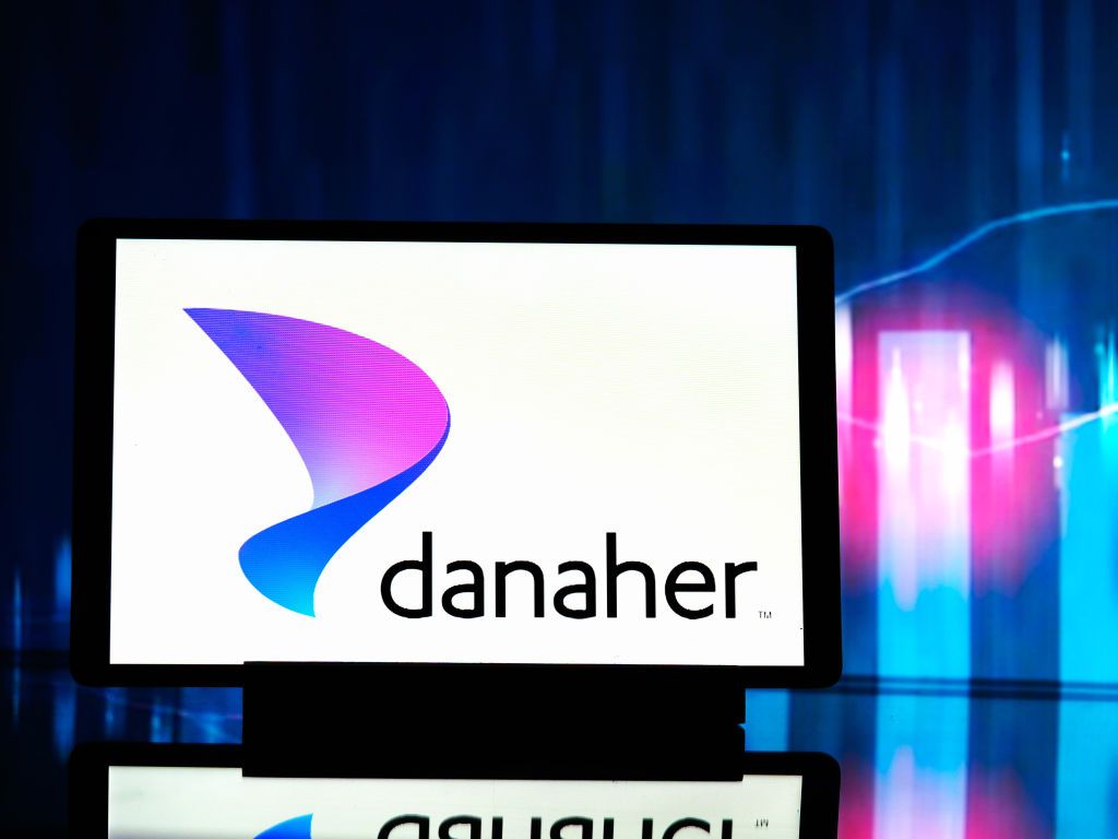 Danaher logo on a tablet with purple and teal bar charts in the background