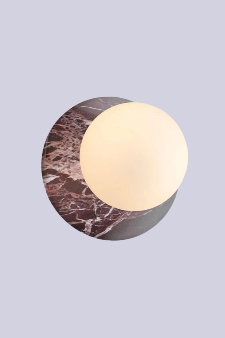 J. Adams Orbit Stone Wall Light in red marble against purple background.
