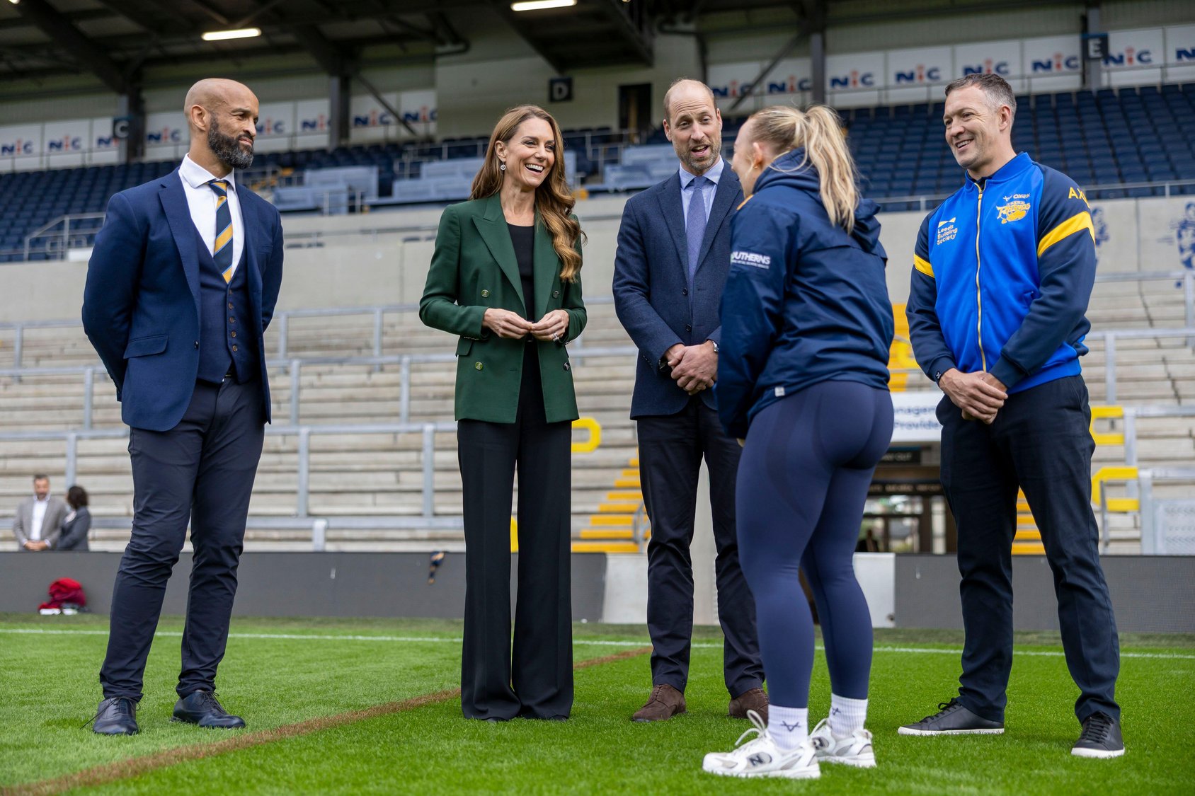 Princess Kate and Prince William talking to people on a rugby field