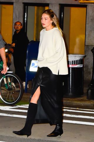 Gigi Hadid wearing a cream jumper and leather maxi skirt GettyImages-1746259377