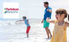 Parkdean Resorts Logo placed over an mage of a family playing on the beach 