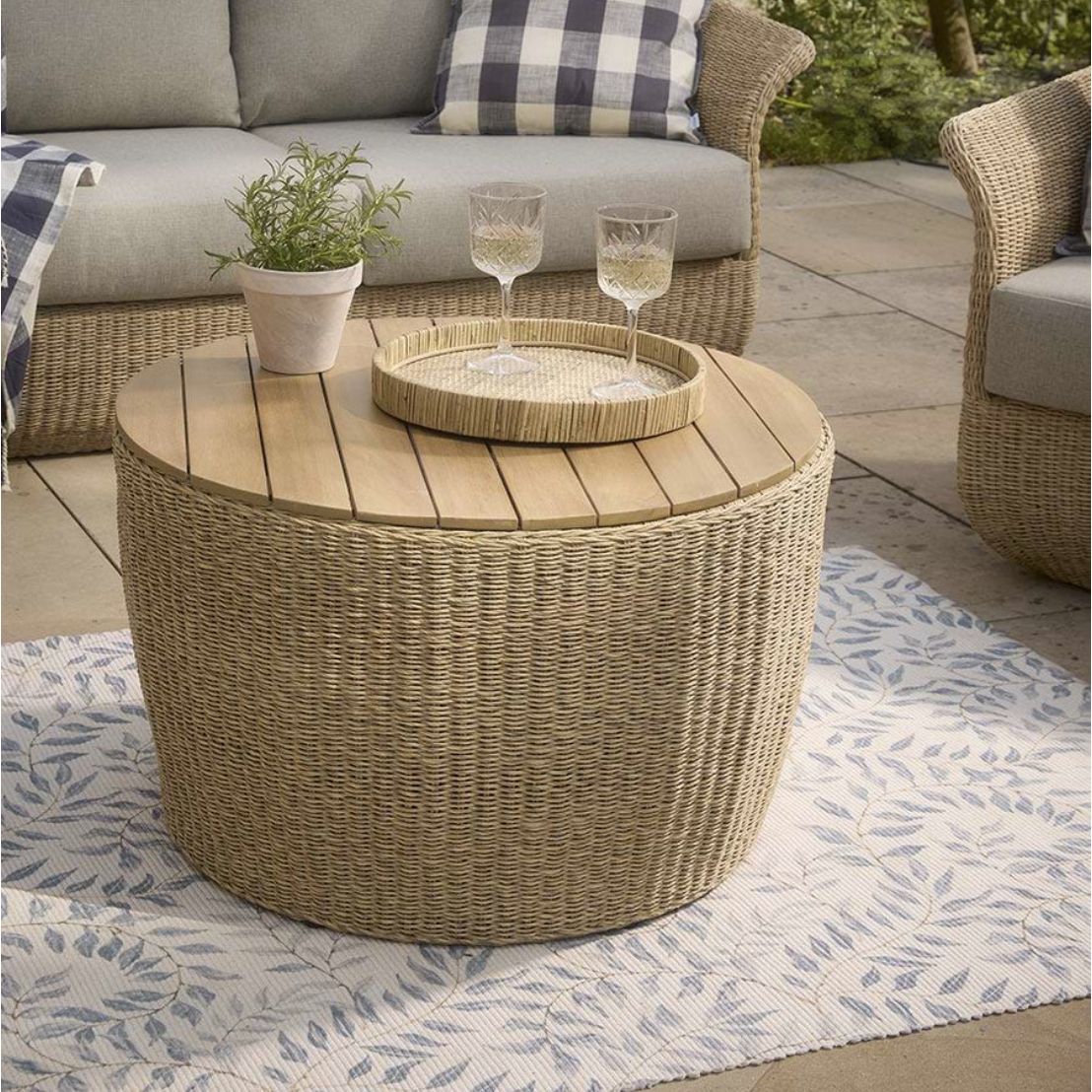 wicker coffee table with wooden lid placed on patio rug