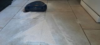 Black Robot Vacuum cleaning up flour scattered on the floor