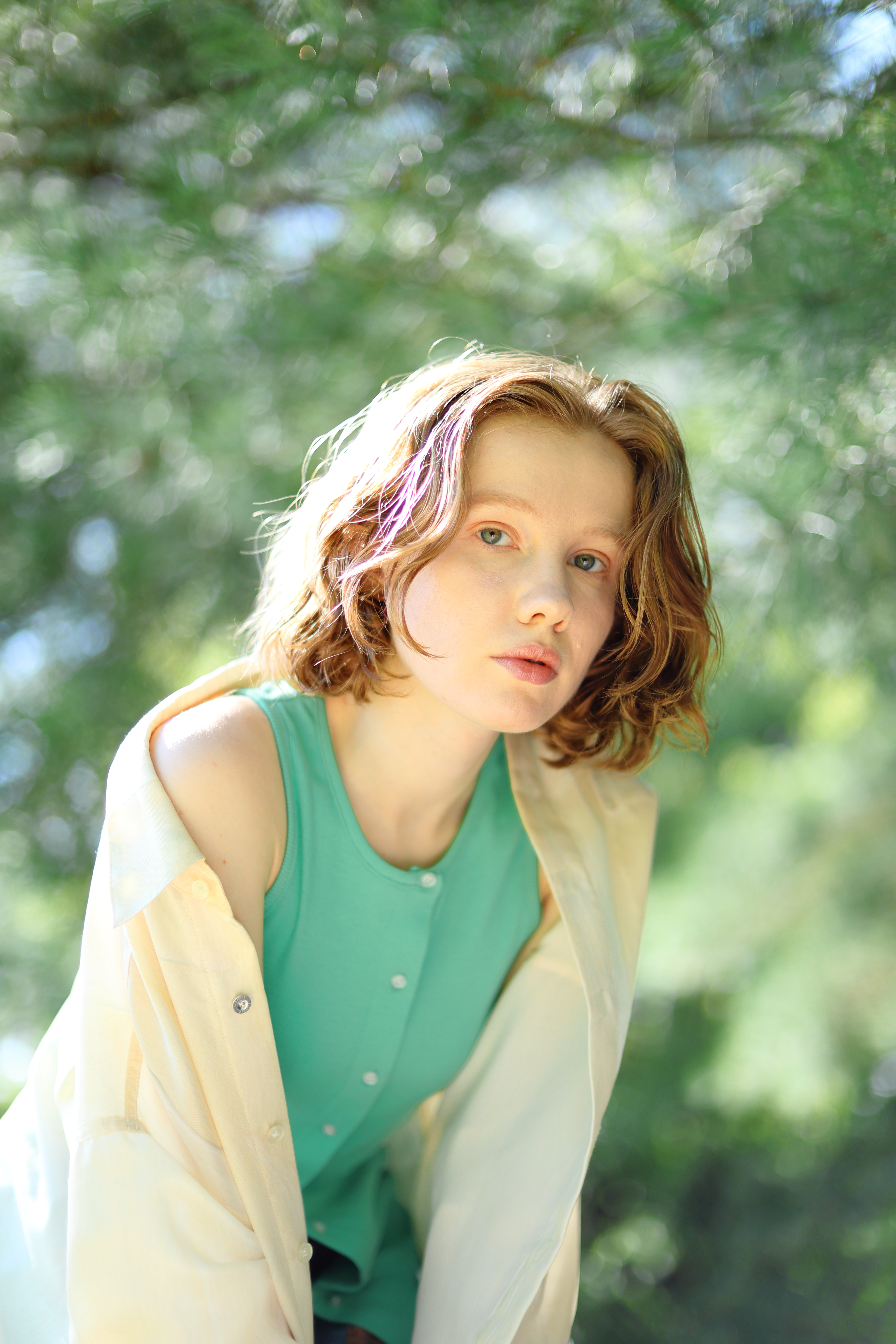 Canon RF 45mm F1.2 STM sample images: a redheaded female in green vest top, tree background