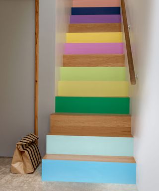 painted woooden staircase with paper bag and wooden handrail