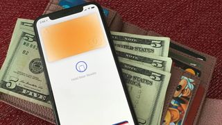 Apple Pay near a wallet full of dollar bills